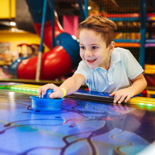 Joyful,Little,Boy,Playing,Air,Hockey,At,Arcade,Centre